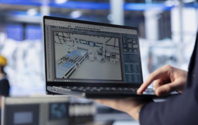 Solar panels plant worker analyzing performance data on laptop and optimizing efficiency. Close up of photovoltaics factory engineer working on innovative solar cells design prototype using notebook